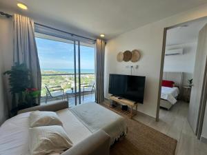 a bedroom with a large bed and a large window at Exclusivo apartasuite con terraza y vista al mar - Bello Horizonte in Santa Marta