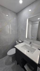 a bathroom with a sink and a toilet and a mirror at Knights Inn Bracebridge in Bracebridge