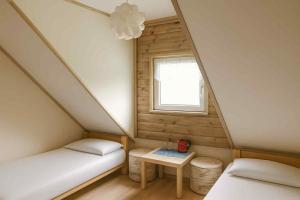 a small room with two beds and a window at Latarnia Wagabundy Bieszczady in Wola Michowa