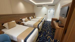 a hotel room with two beds and a flat screen tv at Nuzul Nebras Al Madinah in Medina