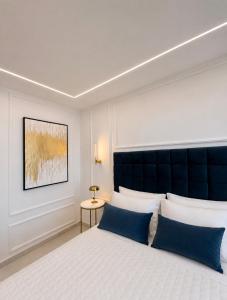 a bedroom with a large bed with blue pillows at The Grand Blue Boutique Hotel in Missolonghi