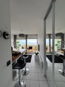 a room with a desk and chairs and a room with a bedroom at Le TAHITI in Frontignan