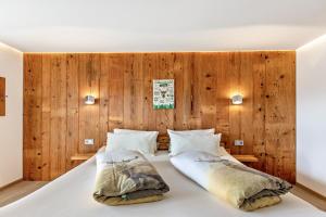 a bedroom with a large bed with wooden walls at Ferienwohnungen Schwarzwaldtraum in Unterkirnach