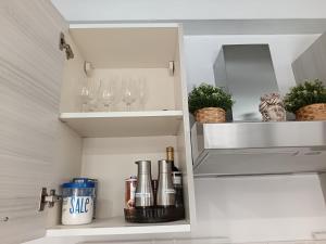 a white cabinet with wine glasses and plants in it at MaraSal in Pozzallo