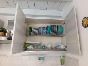 a cupboard filled with plates and dishes in a kitchen at MaraSal in Pozzallo