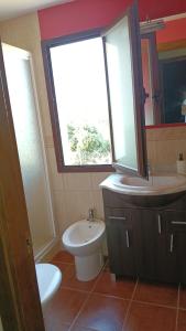 a bathroom with a sink and a toilet and a window at La Quimera in El Ronquillo +13 photos