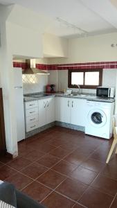 a kitchen with a washer and a washing machine at La Quimera in El Ronquillo
