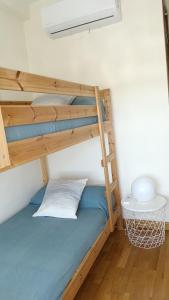 a bedroom with a bunk bed with a blue bedsheet at La Quimera in El Ronquillo