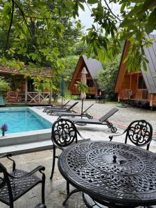 a table and chairs next to a swimming pool at Kvirike Gardens in Kobuleti