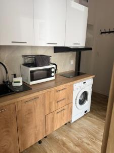 a kitchen with a microwave and a washing machine at Apartamenty na Witosa in Nowa Sól