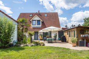 ein Haus mit Terrasse und einem Haus in der Unterkunft Seeperle in Moos