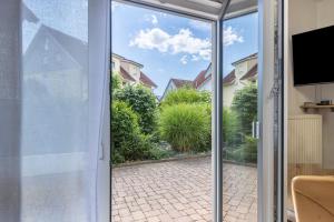 eine offene Glastür mit Blick auf einen Innenhof in der Unterkunft Seeperle in Moos
