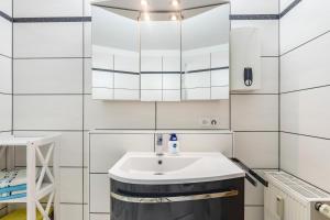 ein weißes Badezimmer mit Waschbecken und Spiegel in der Unterkunft Seeperle in Moos + 15 Fotos