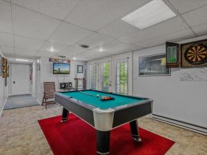 a room with a pool table on a red rug at Blue Badger Cottage -Wifi, Fire Pit, Fireplace, Screen Porch, Game Room, King Bed, Grill in Morton Grove