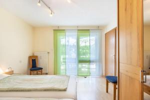 ein Schlafzimmer mit einem Bett und zwei Stühlen in der Unterkunft Seeperle in Moos