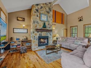 a living room with a stone fireplace at Blue Badger Cottage -Wifi, Fire Pit, Fireplace, Screen Porch, Game Room, King Bed, Grill in Morton Grove