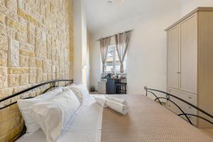 a bed in a room with a brick wall at L'Aurora Bed and Breakfast in Ugento
