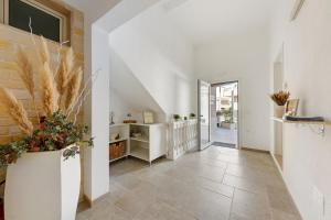 a hallway with white walls and a staircase with plants at L'Aurora Bed and Breakfast in Ugento