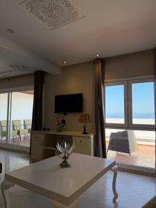 a living room with a table and a tv at Panoramic Sea View Apartment in Riffiene