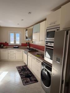 a kitchen with white cabinets and a rug on the floor at Panoramic Sea View Apartment in Riffiene