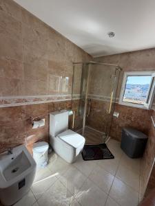 a bathroom with a toilet sink and a shower at Panoramic Sea View Apartment in Riffiene +14 photos