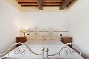a bedroom with a white bed and wooden ceilings at Casolare Sotto le Mura in Anghiari