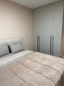 a white bedroom with a large bed and white cabinets at Resident park apartment in Plovdiv