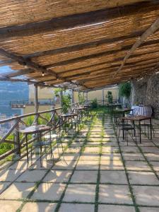 a row of tables and chairs under a wooden roof at L'ARCO DEI QUATTRO VENTI in Minori