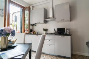 a kitchen with white cabinets and a table at Venier Apartment in Venice