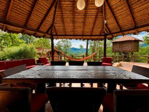 a large black table and chairs in a patio at Valle Verde Lodge - Vista in Samaipata