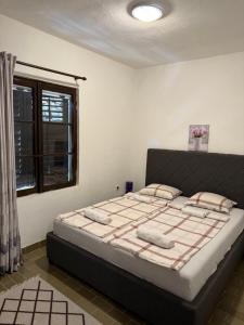 a bedroom with a large bed in a room with a window at Vista apartments in Risan