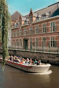 Eine Gruppe von Menschen, die auf einem Boot im Wasser fahren in der Unterkunft Ghent Urbanist Hotel by Harmony in Gent