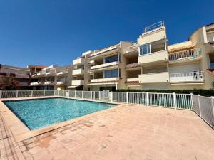 a swimming pool in front of a apartment building at Le TAHITI in Frontignan