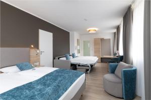a hotel room with two beds and a chair at Zur Alten Post in Nottuln +48 photos