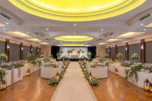 a banquet hall with white tables and flowers at Metro Park View Hotel Kota Lama Semarang in Semarang +43 photos