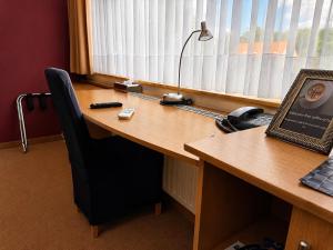 an office cubicle with a wooden desk with a lamp at Axis Hotel Brussels Airport in Kortenberg