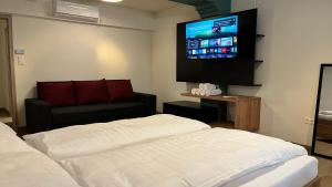 a hotel room with two beds and a flat screen tv at Rezidex Apartmanház in Szeged +48 photos