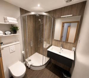 a bathroom with a shower and a toilet and a sink at Axis Hotel Brussels Airport in Kortenberg
