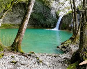 a waterfall in the woods with a pond at 7sopot in Buzet
