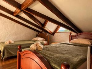 two beds in a attic room with wooden beams at Valle Verde Lodge - Vista in Samaipata