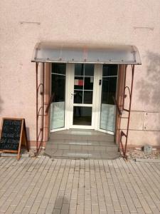 an entrance to a building with a door and a chalkboard at sakura-spa Jesenice in Rakovník +5 photos
