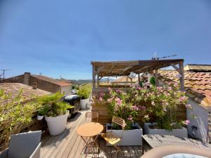 a balcony with plants and tables and chairs at Les Anges de Sigean, Chambres d'hôtes de Luxe,Rooftop Panoramique avec Jacuzzi in Sigean