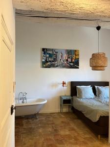 a bedroom with a bed and a bath tub and a sink at Le Son des Violons in Sallèles-dʼAude +28 photos