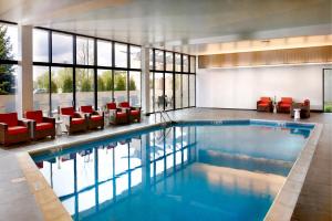a swimming pool in a building with red chairs at Chicago Marriott Naperville in Naperville