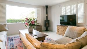 a living room with two couches and a tv at Brendon in Nefyn