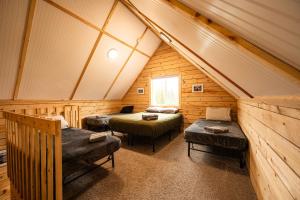 a room with three beds in a log cabin at Halibut Haven, Cabin 7 at Lower Kenai Lodge in Kenai
