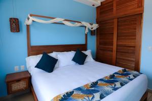 a bedroom with a white bed with blue walls at vivo resort in Chano +53 photos