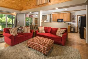a living room with two red couches and a kitchen at Lei Lei Mountainstay in Beech Mountain