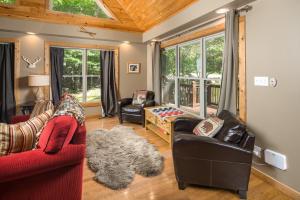 a living room with two red chairs and a couch at Lei Lei Mountainstay in Beech Mountain +23 photos