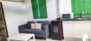 a living room with a blue chair and green cabinets at Muiño Verde in Loña del Monte